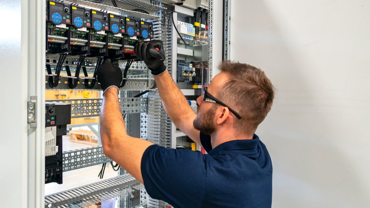 Elektriker verdrahtet einen Schaltschrank mit Sicherungsautomaten